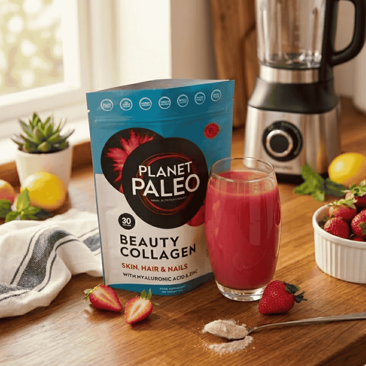 Balení mořského kolagenu Planet Paleo Beauty vedle růžového nápoje s jahodami a ovocem.